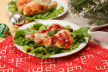 Christmas food: baked chicken leg with cranberry sauce