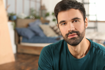 Young bearded man in casual clothes indoors