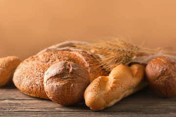 Variety of fresh tasty bread on wooden table