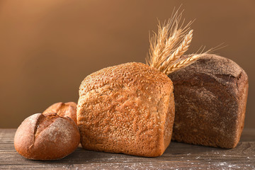 Variety of fresh tasty bread on wooden table