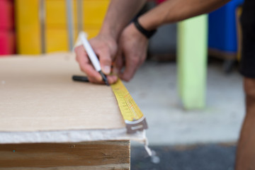 builder with yellow tape measure