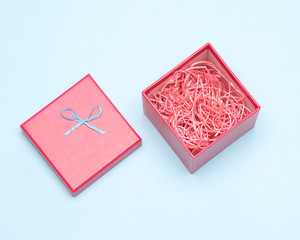 Gift packaging - open red gift box with decorative shavings