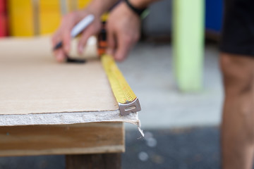 builder with yellow tape measure
