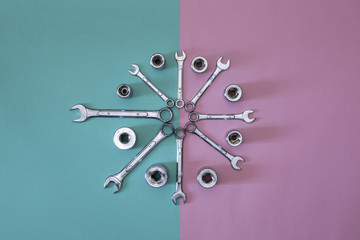 Figure of eight wrenches with heads on a colored background, top view.