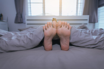Close up of  barefoot,Feet and stretch lazily on the bed after waking up