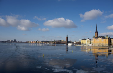 Fototapeta premium A snowy, cold and sunny view of Riddarholmen and the Town City Hall, The Knights' Islet, Stockholm