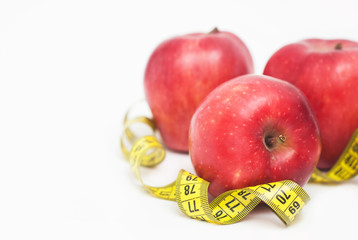 Close Up of Measuring Metter with Red Apples Isolated on White Background with Copy Space. Fat Burning and Weight loss process. Diet and Fitness Concept.