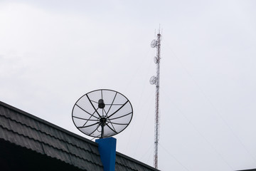 sattlelite and TV antenna and Cellular communication antenna on the roof with cloud sky.