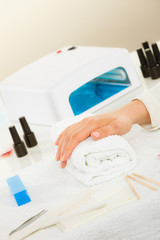 Woman hand on towel, next to manicure set