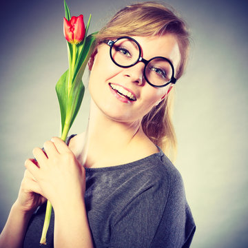 Nerdy girl sniffing flower.