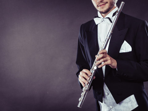 Elegantly dressed musician holding flute