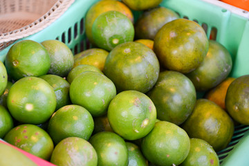 basket with ripe limes on the market in Thailand