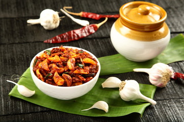 Homemade spicy garlic pickle served with fermenting pickle jar .Indian cuisine food.