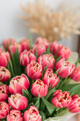Fototapeta premium beautiful luxury bouquet of pink tulips flowers on table. the work of the florist at a flower shop.
