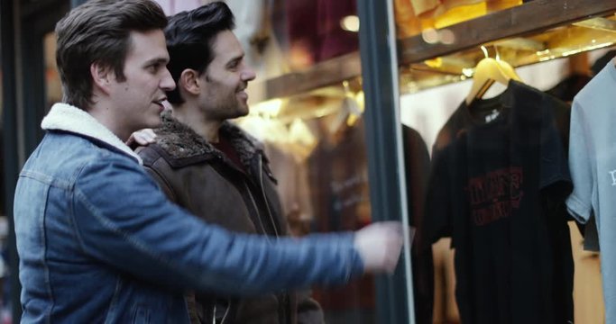 Young male couple window shopping