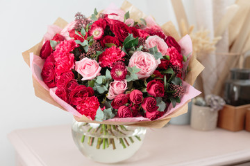 Close-up beautiful luxury bouquet of mixed red and pink flowers in glass vases. the work of the florist at a flower shop. Wallpaper