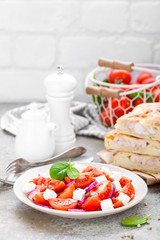 Tomato salad with fresh red onion and feta cheese. Healthy eating