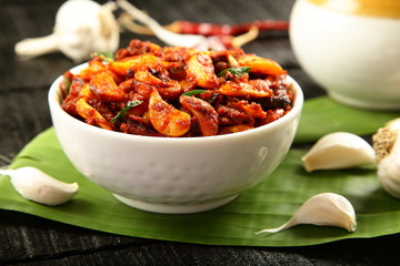 Homemade spicy garlic pickle served in bowl.