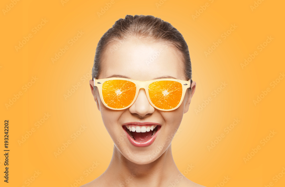 Wall mural happy teenage girl in sunglasses with oranges