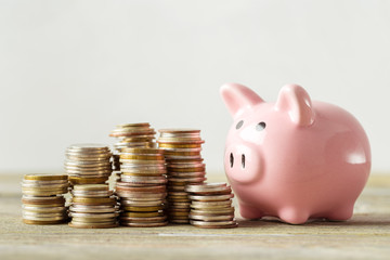 piggy bank with coin on old wooden table