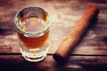 Whiskey or bourbon in a shot glass and cigar