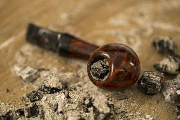 Smoking pipe filled with ash, ash around tube