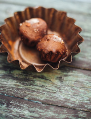Cupcakes on a dark wooden background in an iron dish.