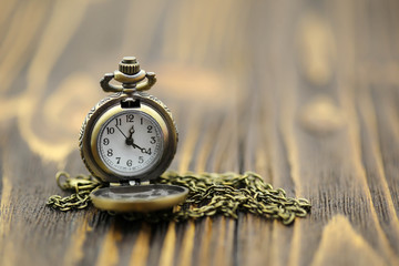 Miniature people : vintage pocket watch on wood background,vintage retro concept.