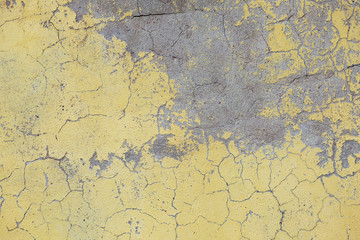 Eine alte gelbe Farbe auf einer Betonwand.