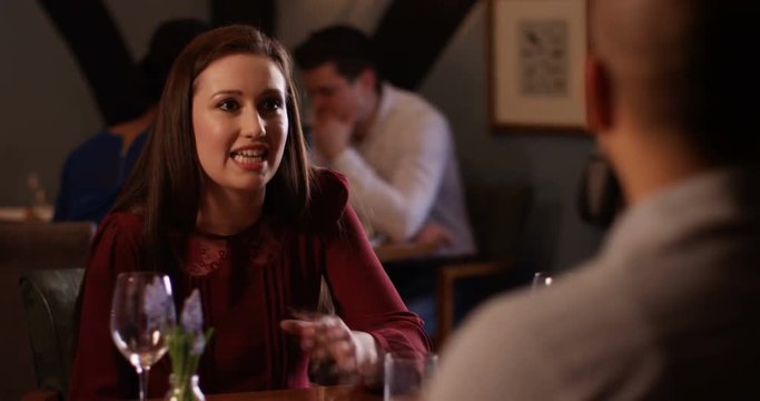 4K Feisty young woman having argument with boyfriend in restaurant throws down her napkin & storms out
