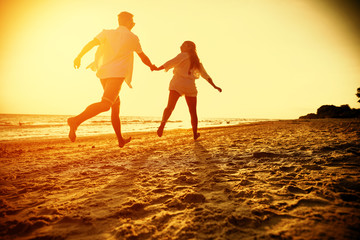 Summer golden sunset and two lovers on beach 