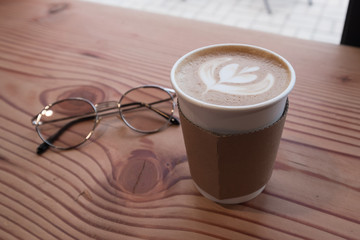 Focus on coffee cup on the wooden table.
