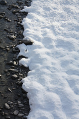 Snow on the river coast in winter in Alps