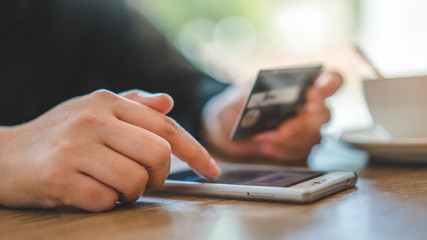 Hands Holding A Smartphone and Debit Card