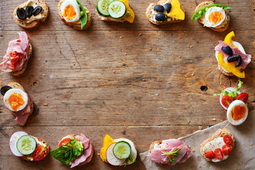Assorted sandwiches food frame on wooden table with copy space. 