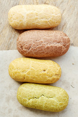 Top view of assorted eclairs on wooden table. 