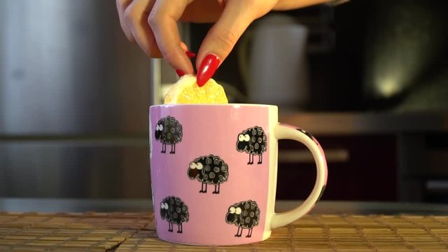 hand puts tea in lemon