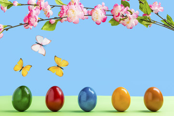 Fünf bunte Eier mit Blumen und Schmetterlinge vor einem blauen Hintergrund