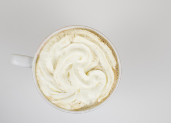 A cup with cream on a light background.