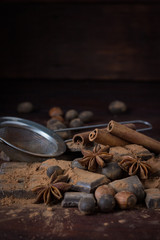 Chocolate, Spices, Spoon with Cocoa, Metal Strainer, Hazelnut on Dark Wood Background