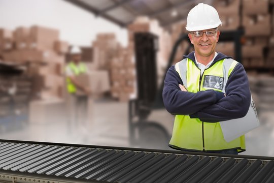 Composite image of worker wearing hard hat in warehouse