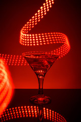 Martini glass on a red background with lights