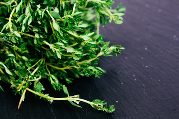 Bunch of fresh thyme on a black background. Top view image. Copyspace for your text