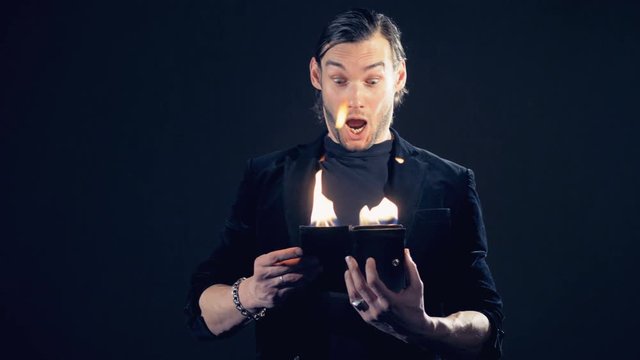 Magician is noticing a flame in the purse and pretending to be scared.