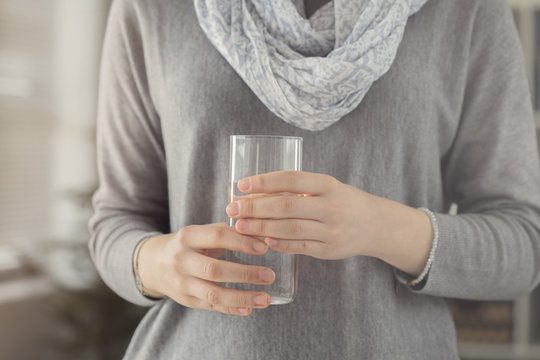Young woman holding glass of water