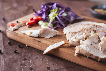 Meat baked in the oven, sliced into pieces with salad on a wooden Board. Horizontal. Close up. Place for text.  Spring salad with meat. Horizontal. Close up. Place for text.  Deadpan