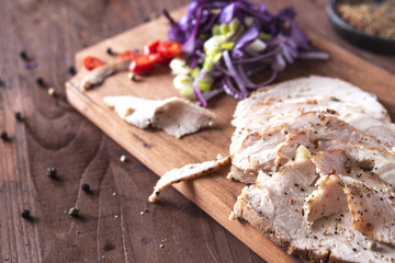 Meat baked in the oven, sliced into pieces with salad on a wooden Board. Horizontal. Close up. Place for text. Spring salad with meat. Horizontal. Close up. Place for text.  Deadpan