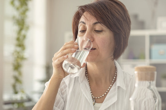 Middle aged woman drinking water