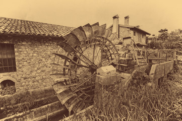 Old water wheels of a watermill. Vintage style picture. Adding grain to give an old photo effect.