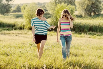 Woman with daughter teen walking in nature